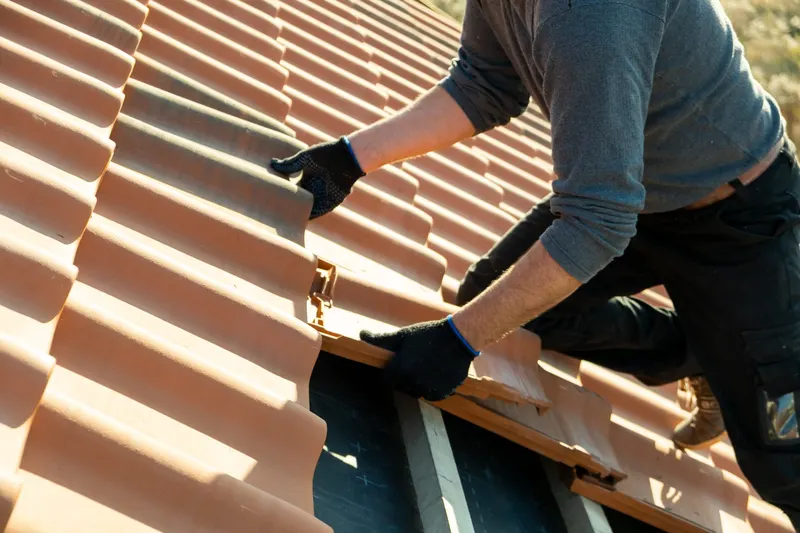 Roofer replacing broken roof tiles during a roof repair in Knaresborough
